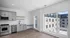 Bright and modern kitchen with sleek gray cabinets, stainless steel appliances, and expansive windows offering a stunning view of the building exterior.