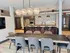 Modern open-concept kitchen and dining area with sleek appliances, elegant lighting, and stylish seating in a contemporary apartment.