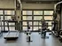 Modern fitness center with cardio equipment, featuring treadmills and stationary bikes, set in an urban apartment gym with large windows.