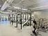 Modern fitness center equipped with state-of-the-art weightlifting machines, squat racks, and ample natural light for an energizing workout experience.