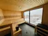 Luxurious wooden sauna with panoramic city views, offering a serene and relaxing retreat in a modern urban setting.