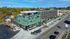 Contemporary multi-story building with a vibrant facade, ample parking, and rooftop amenities, set in a bustling urban neighborhood.