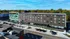 Modern apartment building with sleek design, large windows, and convenient location near lush greenery.