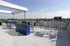 Chic rooftop terrace with modern seating, blue planters, and stunning skyline views.