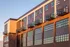 Modern apartment building with stylish balconies and ample windows, showcasing contemporary architecture under warm sunlight.