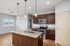 Modern kitchen design with granite countertops, stainless steel appliances, and elegant pendant lighting in a bright and spacious open layout.