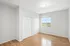 Bright, spacious bedroom with elegant wood flooring, large windows offering scenic views, and ample closet space.