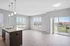 Bright, modern open-concept living space with hardwood floors, a stylish kitchen island, and large windows offering an inviting view.