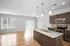 Modern open-concept kitchen with sleek granite countertops, stainless steel appliances, and large windows providing ample natural light.