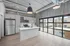 Chic urban kitchen with modern appliances, sleek cabinets, and expansive windows offering abundant natural light.