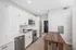 Modern kitchen with sleek white cabinetry, stainless steel appliances, and elegant wood flooring, perfect for contemporary living.