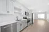 Modern kitchen with sleek stainless steel appliances, white cabinetry, and a bright open-concept layout.