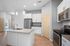 Modern kitchen with sleek stainless steel appliances, elegant granite countertops, and stylish pendant lighting.