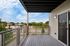 Modern apartment balcony with sleek railing overlooking a vibrant urban neighborhood, perfect for relaxing or entertaining.