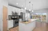 Modern kitchen with granite countertops, stainless steel appliances, pendant lighting, and large windows offering scenic views.