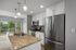 Modern kitchen with granite countertops, stainless steel appliances, and pendant lighting, overlooking a scenic balcony view.