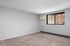 Bright and spacious room with neutral walls, soft carpet, and large window offering natural light.