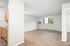 Bright, open-concept living area with modern wooden flooring and a large window for natural light.
