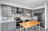 Contemporary kitchen with sleek gray cabinetry, modern appliances, and a stylish wooden island countertop.