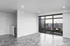 Bright, modern apartment interior with large windows offering a stunning cityscape view, featuring elegant flooring and ample natural light.