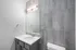 Elegant bathroom with sleek gray tiles, modern vanity, and ample lighting.