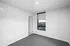 Bright and modern room with a plush carpet and large window overlooking vibrant city views.