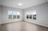 Bright room with large windows offering scenic views, featuring sleek hardwood floors and soft neutral walls, ideal for a modern living area.