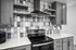 Modern kitchen with sleek gray cabinets, elegant tile backsplash, and state-of-the-art appliances.
