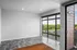 Modern apartment featuring large floor-to-ceiling windows with a scenic view, sleek gray tile flooring, and a spacious open area full of natural light.