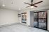 Modern apartment interior featuring sleek wooden ceiling fan, large windows with city view, and elegant gray flooring.