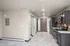Modern kitchen with sleek dark cabinets, stainless steel appliances, and marble tile flooring in a contemporary apartment.