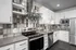 Modern kitchen with sleek stainless steel appliances, stylish tile backsplash, and crisp white cabinetry.