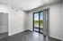 Bright empty room with sleek flooring, large sliding glass door to a balcony, and natural scenery view.