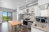 Modern kitchen with stainless steel appliances, spacious wooden island, and scenic balcony view enhancing natural light.