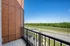 Charming balcony view showcasing lush green surroundings and a peaceful road, perfect for relaxation.