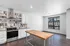Modern kitchen featuring sleek stainless steel appliances, stylish backsplash, and a spacious wooden island in a bright open layout.