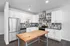 Modern kitchen with sleek stainless steel appliances, stylish tiled backsplash, and a spacious wooden island.