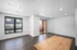 Bright modern living room with hardwood floors, large windows, and a balcony for outdoor enjoyment.