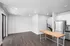 Modern open-concept kitchen and living area with stainless steel appliances, hardwood floors, and ample natural light.