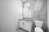 Modern bathroom with sleek grey tiles, a stylish vanity, and contemporary lighting.