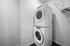 Modern laundry room with stacked washer and dryer, offering efficient and sleek design.