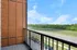 Inviting balcony with serene view of lush greenery and blue skies, perfect for relaxing and enjoying nature.