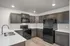 Modern kitchen with sleek white countertops, dark wood cabinetry, and stainless steel appliances offering ample storage and contemporary elegance.