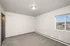 Bright and spacious bedroom featuring neutral tones, plush carpeting, and a large window with scenic views.
