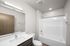 Modern bathroom with sleek fixtures, spacious bathtub, and elegant vanity for a luxurious touch.