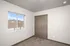 Bright and cozy bedroom with large window, modern closet doors, and plush carpeting.