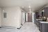 Modern kitchen featuring dark wood cabinets, sleek appliances, and stylish marble flooring, offering a welcoming entrance.
