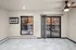Modern apartment living area with large windows, marble-style flooring, and ceiling fan offering a stylish city view.