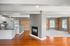 Charming open-concept living space with hardwood floors, modern kitchen, and exposed brick accents.