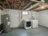 Spacious basement laundry room with modern washer, dryer, and hot water heater, showcasing ample space and potential for customization.